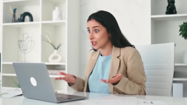 Podenerwowana sfrustrowana arabska lub indyjska kobieta biznesu, pracownik firmy, dyrektor finansowy, siedzi w biurze, zdezorientowana patrzy na ekran laptopa, otrzymuje słabe wyniki od pracowników - Materiał filmowy, wideo
