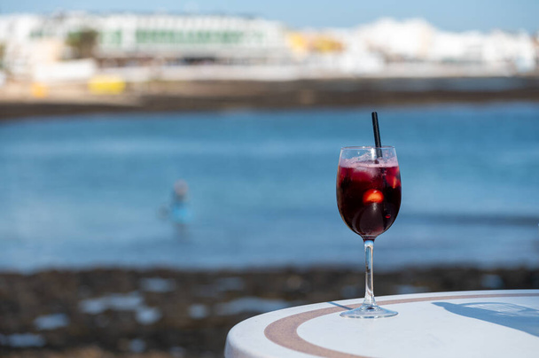 Glas koude sangria zoete wijn geserveerd met sinaasappel in strandcafé Corralejo, Fuerteventura, Spanje - Foto, afbeelding