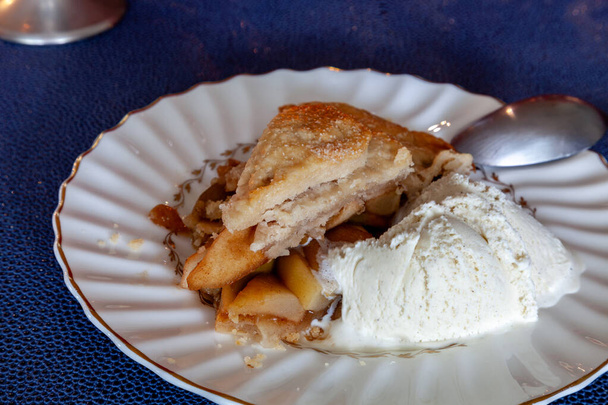 Egy szelet házi készítésű ínyenc almás pite egy ünnepi asztalon gyertyákkal és fényekkel.. - Fotó, kép