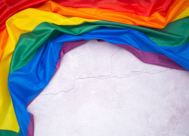 Le drapeau arc-en-ciel (LGBT) est sur un sol en ciment avec de l'espace pour le texte. Vue de dessus. Pose plate. Concept d'amour. - Photo, image