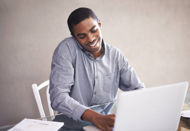 Happy, businessman and laptop with phone call for consulting, customer service or online advice at home. Black man, African employee or consultant with smile, talking on mobile smartphone at house. - Photo, Image