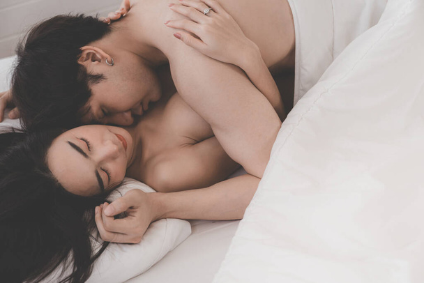 Yatak odasında Asyalı çiftin yan görüntüsü. Yatakta tutkulu bir çift. Sevgililer Günü. Sevgi ve mutluluğu birlikte hissetmek. Kavram: Aşk, seks, tatlım, tatlı, aktivite, yaşam tarzı. seçici odak - Fotoğraf, Görsel