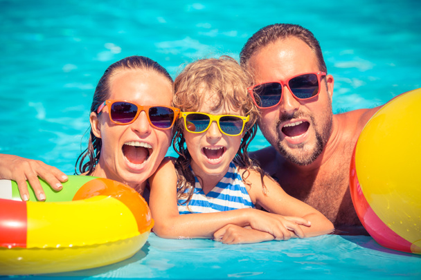 Happy family playing in swimming pool - Fotó, kép