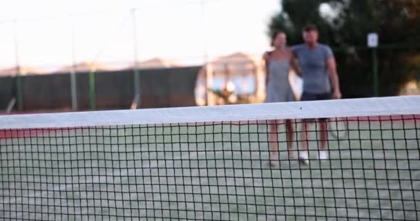 Férfi és nő a teniszpályán kommunikálnak. Tenisz játék - Felvétel, videó