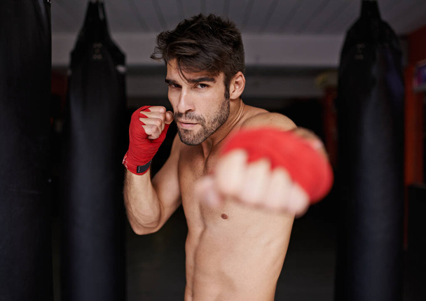 Boxer, gym and portrait for fitness, punch and wellness in strong training for confidence to fight. Man, sport and boxing athlete in sports, challenge and shirtless ready to exercise for mma. - Photo, Image