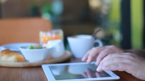 tabletta számítógép kávézóban kávét iszik az ember - Felvétel, videó