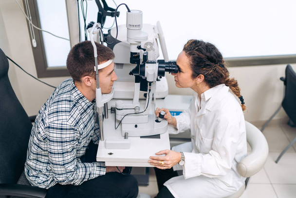 Arzt untersucht Patientin mit modernem Augenheilgerät. - Foto, Bild