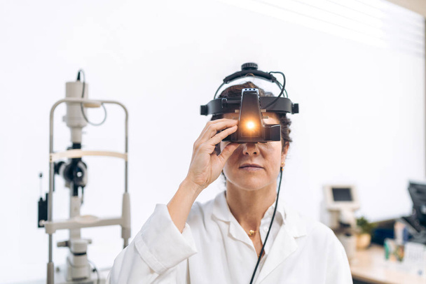 Augenoptiker kalibriert hochentwickeltes Augenuntersuchungswerkzeug. - Foto, Bild