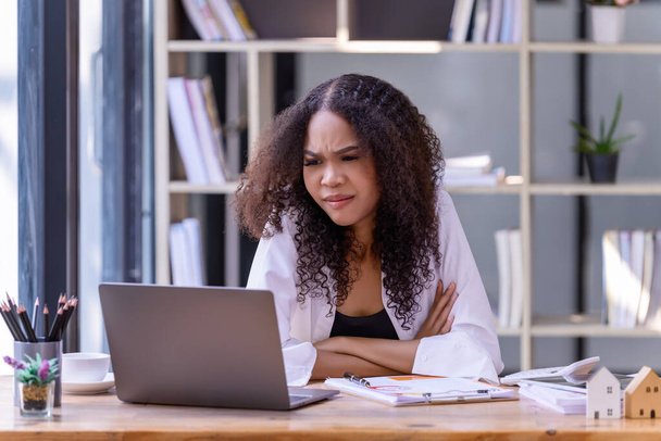 İş kadınları, ofiste dizüstü bilgisayar ve kağıt belgeler önünde çalışmakla strese girerler. İş konsepti. - Fotoğraf, Görsel
