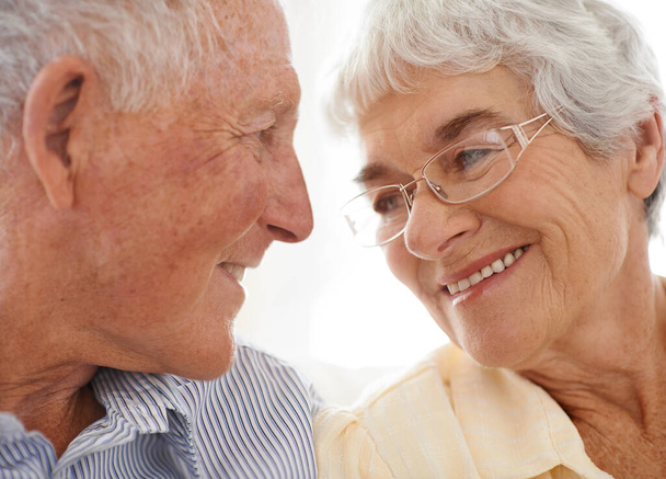 Para, senior i szczęśliwy lub miłość w patrząc, domu i zrelaksować się razem dla więzi i uśmiech. Osoby starsze, romans i opieka w małżeństwie lub związek na emeryturze, zbliżenie i bezpieczeństwo w domu. - Zdjęcie, obraz