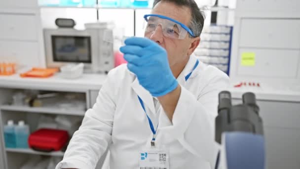 Científico maduro analizando muestras en un laboratorio moderno - Imágenes, Vídeo
