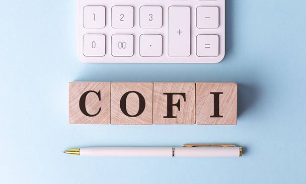 COFI egy fa kockán tollal és számológéppel, pénzügyi koncepció - Fotó, kép
