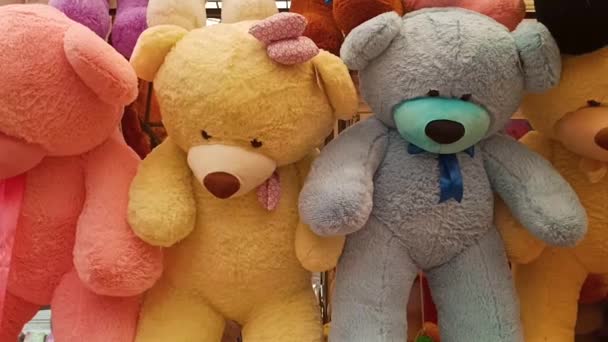 A large number of colorful large stuffed animals, including teddy bears, hang in the display case, creating a panoramic view. - Footage, Video