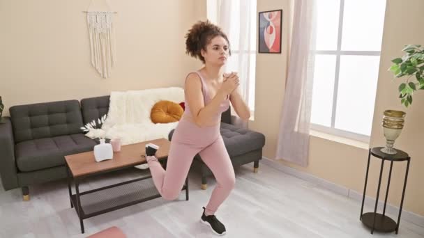 Mujer joven ejercitándose en una elegante sala de estar, mostrando bienestar, fitness y diseño interior moderno. - Imágenes, Vídeo