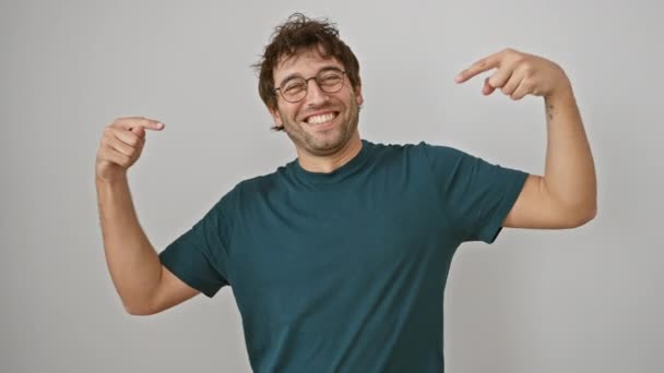 Fröhlicher junger hispanischer Mann mit Brille nimmt selbstbewusste Pose ein, zeigt mit dem Finger auf sich selbst auf weißem Hintergrund und strahlt Stolz und Glück aus - Filmmaterial, Video