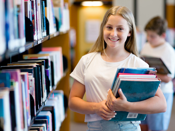 Teenage girl in library - Foto, afbeelding