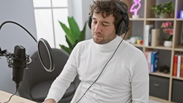 Fajny latynoski facet medytujący w stylu ze słuchawkami w studiu radiowym - epicka koncepcja zen i fuzji jogi - Materiał filmowy, wideo