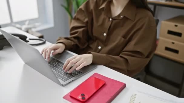 Modern ofiste dizüstü bilgisayarla çalışan beyaz bir kadın. İç mekan bitkileri ve depolama kutularıyla.. - Video, Çekim