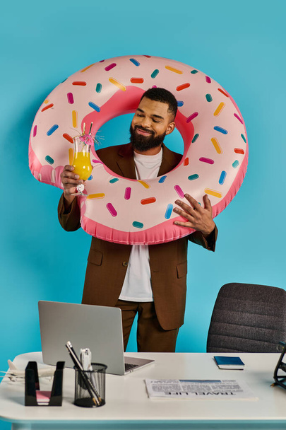 Um homem brinca com um donut gigante na frente de seu rosto, criando uma cena caprichosa e humorística. - Foto, Imagem