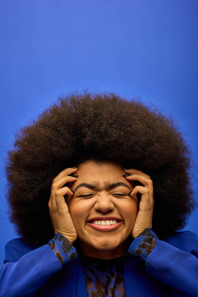 Стильна афроамериканська жінка з кучерявим хребтом руки до обличчя в момент роздумів. - Фото, зображення