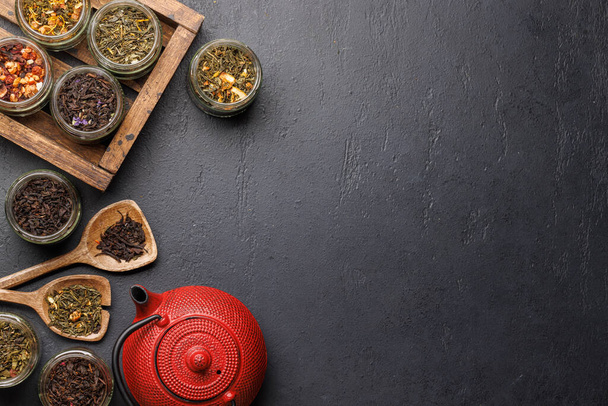 Teaidő-választék: különféle száraz tealevelek és teáskanna. Lapos fekvésű fénymásoló - Fotó, kép