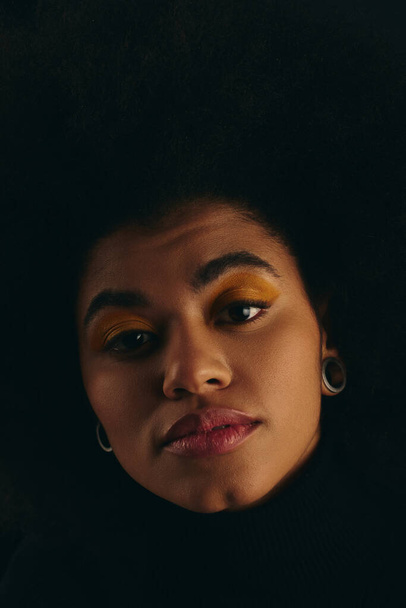 Detailní záběr stylové Afroameričanky s objemným afro účesem na pulzujícím pozadí. - Fotografie, Obrázek