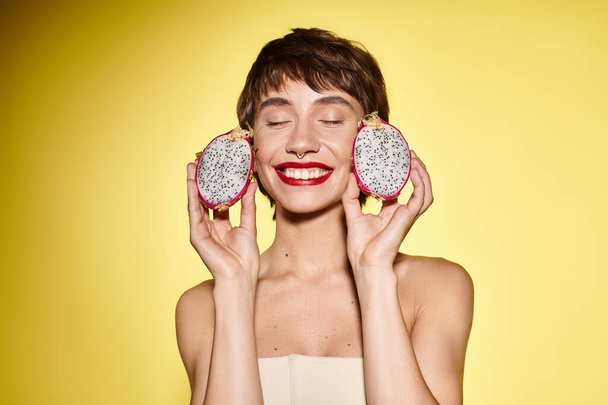 Jonge vrouw houdt speels twee donuts voor haar gezicht. - Foto, afbeelding