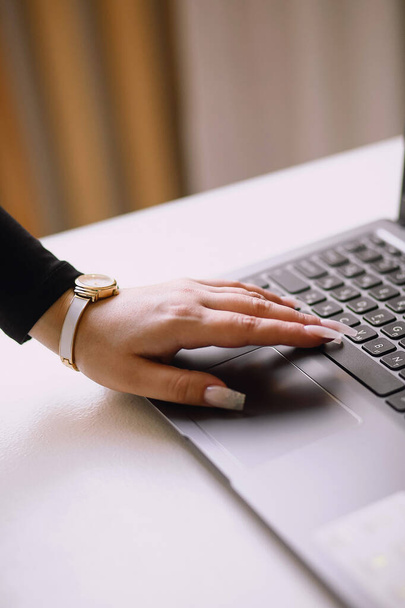 Close-up foto van de hand van de vrouw typen op een laptop toetsenbord. Freelance en werk op afstand. Moderne vrouwelijke levensstijl. Kopieer ruimte voor tekst - Foto, afbeelding