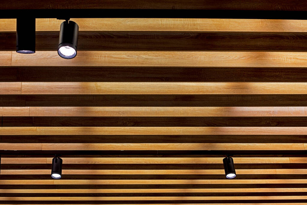 abstrakcyjna nowoczesna drewniana powierzchnia z lampami w nowoczesnym wnętrzu - Zdjęcie, obraz