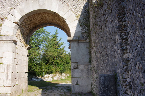 Αρχαιολογικός χώρος της Αλτίλιας: Σε πρώτο πλάνο μια τεχνική περίτεχνου τείχους που χρησιμοποιήθηκε από τη Ρωμαϊκή Αυτοκρατορία στο παρασκήνιο μία από τις τέσσερις πύλες πρόσβασης στη Ρωμαϊκή πόλη. Sepino, Molise, Ιταλία - Φωτογραφία, εικόνα