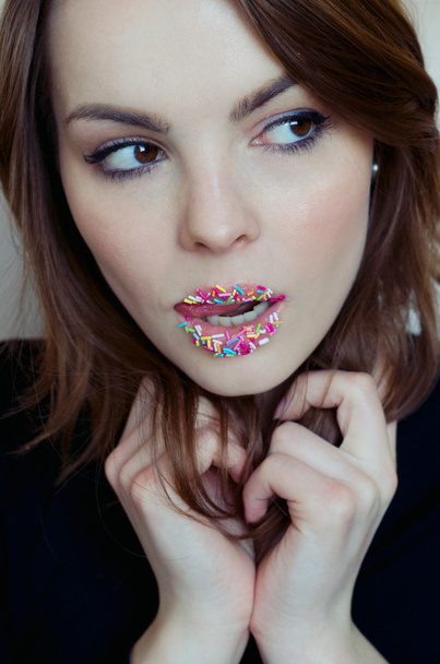 Vrouw met snoepjes op haar lippen. - Foto, afbeelding