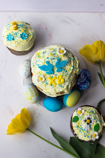 Wielkanoc. Widok z góry na ciasto wielkanocne, jajka i żółte tulipany - Zdjęcie, obraz