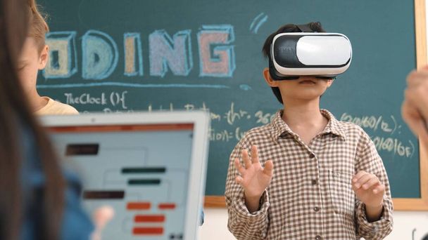 VR kulaklık takan enerjik bir çocuk sınıfta sanal dünyaya giriyor. Öğrenci programlama sistemi, çocuk elektronik panoyu tamir ederken yapay zeka ile mühendislik komut yazılımı oluşturdu. Pedagoji. - Fotoğraf, Görsel