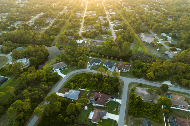 Widok z lotu ptaka krajobraz z prywatnych domów między zielonymi palmami na Florydzie spokojnej dzielnicy mieszkalnej. - Zdjęcie, obraz
