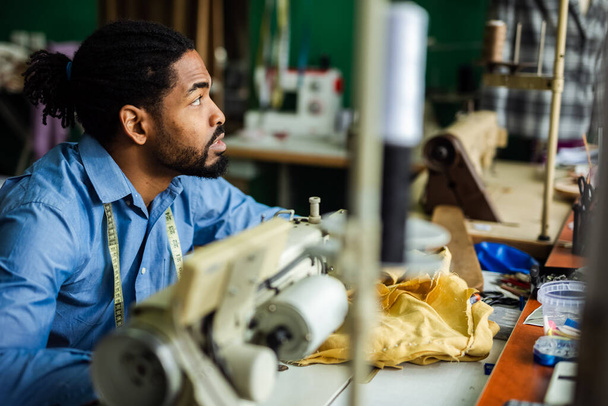 Jovem alfaiate afro-americano costurar com uma máquina de costura em seu próprio atelier - Foto, Imagem