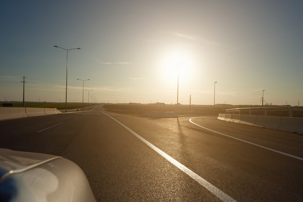 Οδηγώντας στην εθνική οδό το ηλιοβασίλεμα - Φωτογραφία, εικόνα