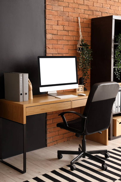 Blanco computer monitor met mappen op tafel in modern kantoor - Foto, afbeelding
