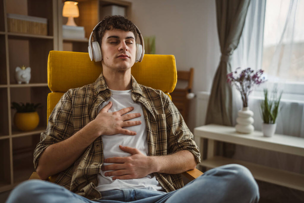 One teen man doing guided meditation yoga self care practice at home - Photo, Image