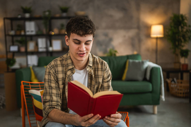 Young man caucasian teenager read book study at home education concept - Photo, Image