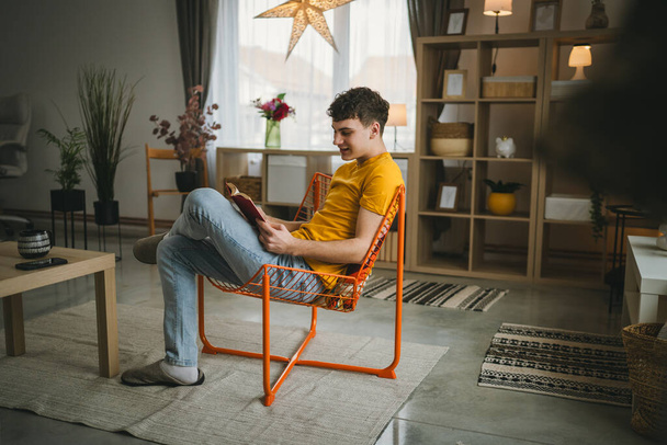Fiatal férfi kaukázusi tinédzser olvasni könyv tanulmány otthon oktatás koncepció - Fotó, kép