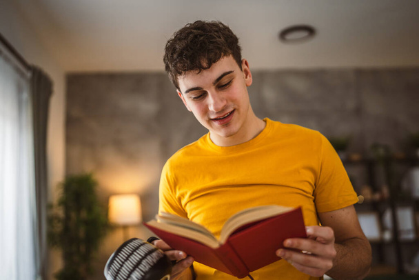 Nuori mies valkoihoinen teini lukea kirjan tutkimuksen kotona koulutus käsite - Valokuva, kuva