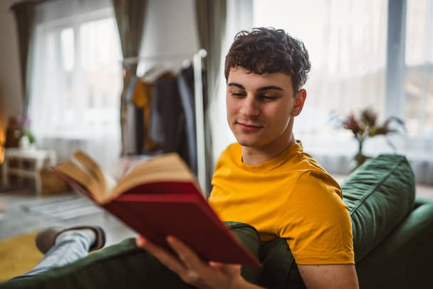 Giovane adolescente caucasico leggere libro studio a casa concetto di educazione - Foto, immagini