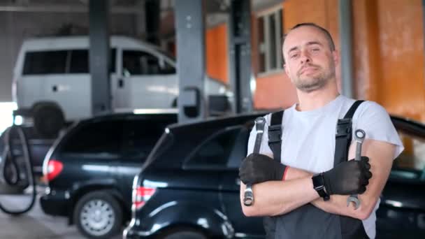 Mann steht mit Schraubenschlüssel vor Auto - Filmmaterial, Video