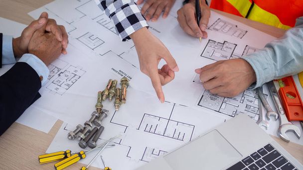 A mérnökök és a tulajdonos megbeszélik az építési terv ellenőrzését és felülvizsgálatát. Vállalkozói ellenőrzés rajz megkezdése előtt projekt civil. projekttervezés, tanácsadás, építészet. - Fotó, kép