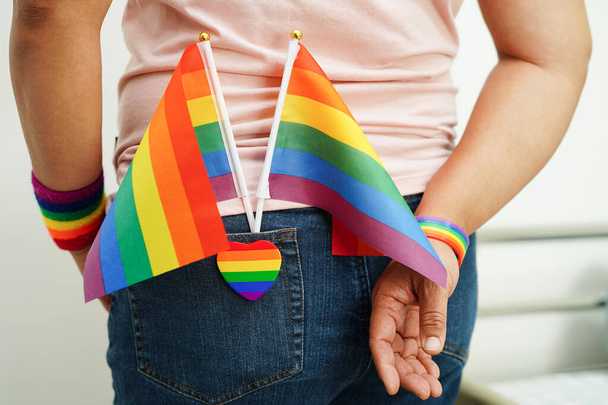 Ασιάτισσα με σημαία ουράνιου τόξου, δικαιώματα συμβόλων ΛΟΑΤ και ισότητα των φύλων, μήνας υπερηφάνειας ΛΟΑΤ τον Ιούνιο. - Φωτογραφία, εικόνα
