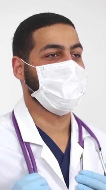 Lekarz, zakładając środki ochrony osobistej, trzyma strzykawkę podczas noszenia maski i rękawiczek.. - Materiał filmowy, wideo