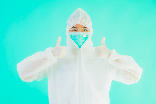 Portré gyönyörű fiatal ázsiai orvos nő visel ppe vagy egyéni védőfelszerelés védelme érdekében a coronavirus vagy covid19 kék izolált háttér - Fotó, kép