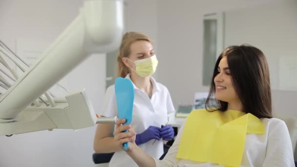 Egy nő ül egy fogorvosi székben, beszélgetve a fogorvosával, miközben a víz szivárog egy közeli csapból.. - Felvétel, videó