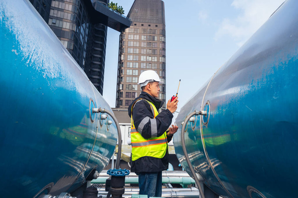 L'image montre un ingénieur qualifié inspectant un réseau de pipelines dans une installation pétrochimique. le concept de projets liés à la pétrochimie, au génie et à l'inspection industrielle ;. - Photo, image