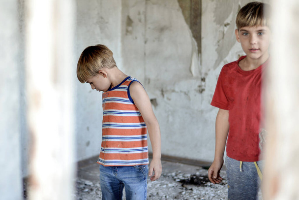 Kinder in einem abgebrannten Haus verloren infolge von Feindseligkeiten und Naturkatastrophen ihr Zuhause. - Foto, Bild